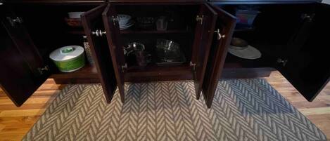Una cocina con armarios de madera, alfombra con estampado de espiga y piso de madera.