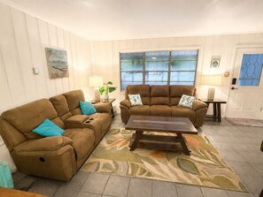 A living room with two sofas, a coffee table, and a window with blinds. - Blue Seahorse Coastal Retreat 3BR/2BA pet friendly, privacy fenced yard (Rockport)
