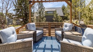 A covered outdoor seating area with wicker furniture and a patterned rug. - Eagle Crest Retreat | 6 Resort Passes Included (Redmond)