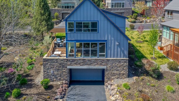 A modern two-story house with a stone foundation, a garage, and a landscaped yard. - Eagle Crest Retreat | 6 Resort Passes Included (Redmond)