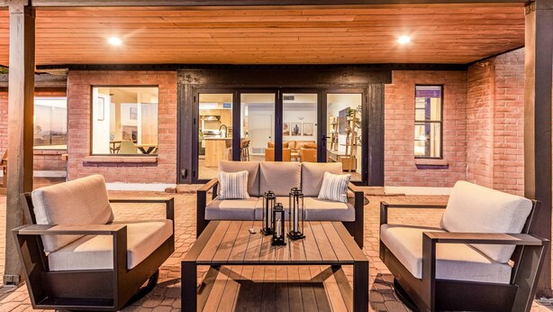 An outdoor seating area with a sofa and two chairs, a table, and a brick wall in the background. - Private and Quiet with stunning views (Tucson)