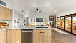 A modern kitchen with wooden cabinetry, a dishwasher, and a large island with a sink. - Private and Quiet with stunning views (Tucson)