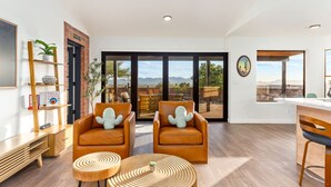 A spacious living area with two leather armchairs, a wooden coffee table, and a bookshelf. - Private and Quiet with stunning views (Tucson)