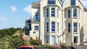 A two-story building with a bay window on the second floor and a balcony on the first floor. - 2 bedroom accommodation in Woolacombe (Woolacombe)
