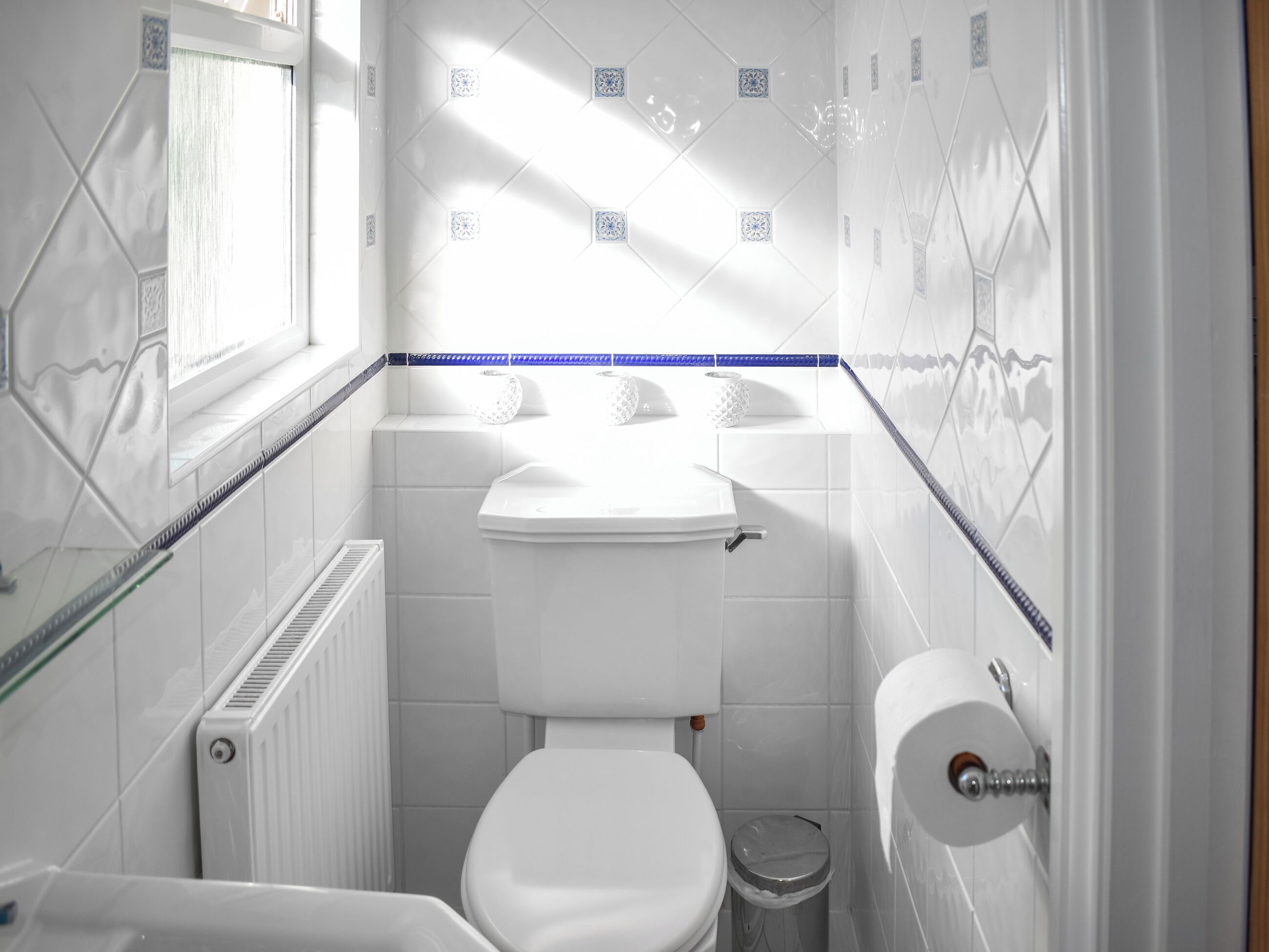 Une petite salle de bain compacte, équipée de toilettes, d’un lavabo et d’un radiateur.