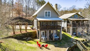 Une maison à deux étages dotée d’un patio couvert, d’un espace salon extérieur et d’un jacuzzi.