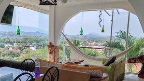 A spacious living area with a large window offering a view of a mountainous landscape. - Encantadora casa de 4 alcobas con WIFI (Tocaima)
