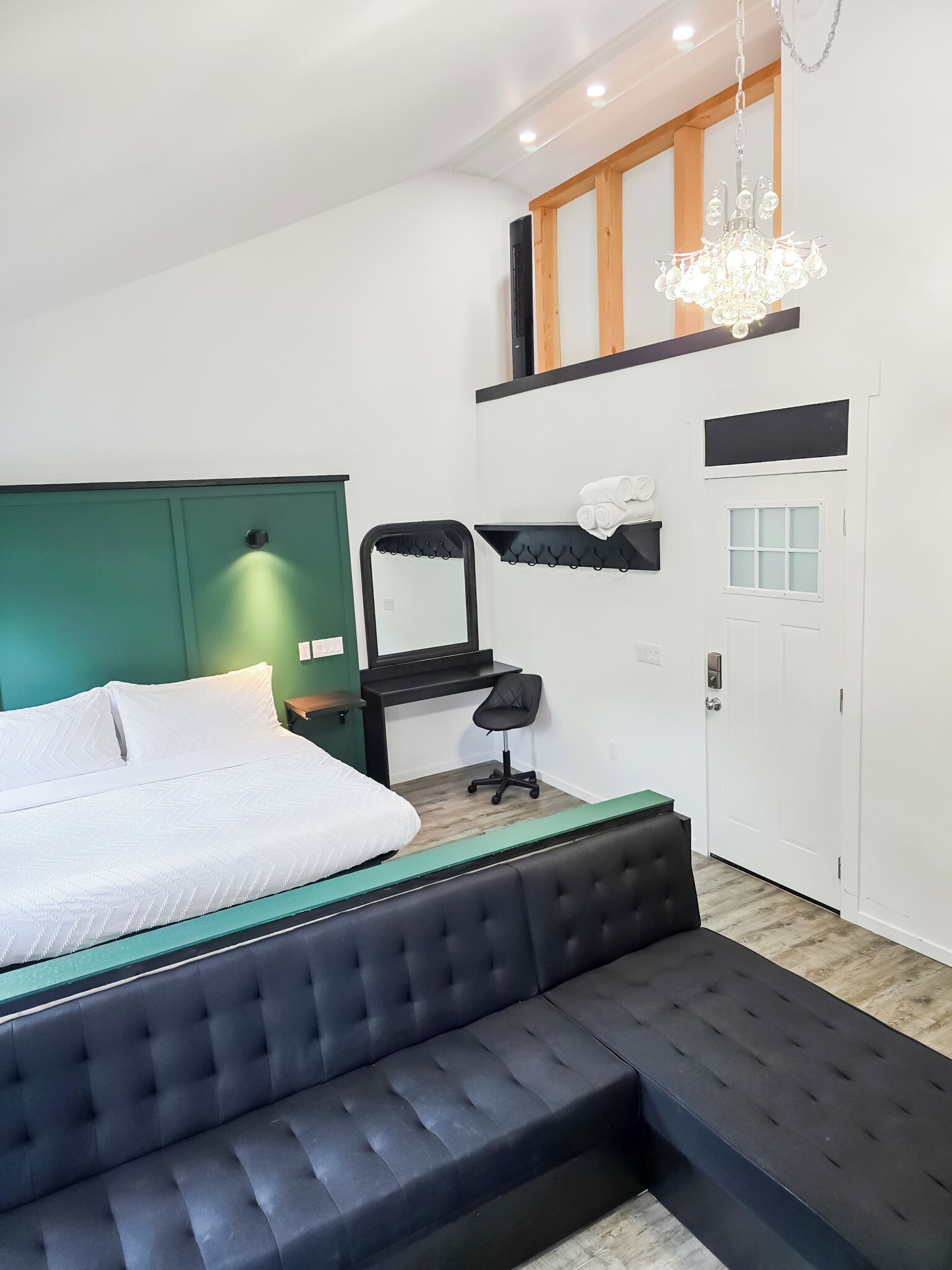A modern bedroom with a bed, a bench, a desk, and a chair.