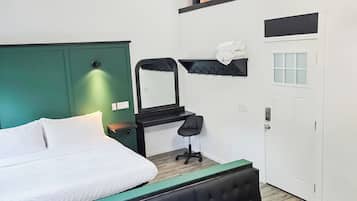 A modern bedroom with a bed, a bench, a desk, and a chair.