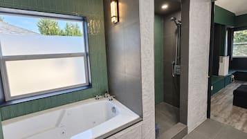 Un baño moderno con bañera, ducha y ventana con vistas al exterior.