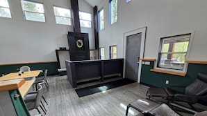 A modern interior with a reception desk, seating area, and large windows. - Copper Rose Retreat B&B (Invermere)