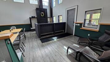 A modern interior with a reception desk, seating area, and large windows.