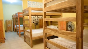 Bunk beds in a room with a fan and a decorative wall. - Hostal Casa Maricel (Granada)