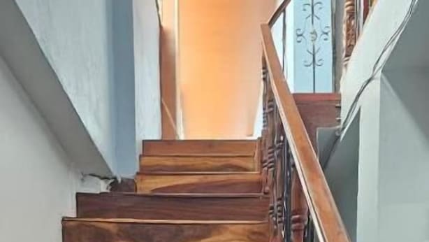 A wooden staircase with a metal railing. - Hostal Casa Maricel (Granada)