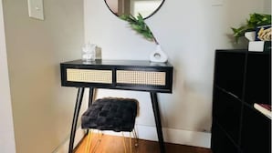 A room with a black vanity table, a round mirror, a small stool, and a potted plant. - Hollywood sign view/ 5 mins from universal studio (West Hollywood)