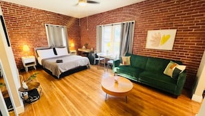 A room with a bed, a green sofa, a round coffee table, and a dining area with a table and chairs. - Hollywood sign view/ 5 mins from universal studio (West Hollywood)
