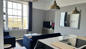 Een moderne woonkamer met een bank, een eettafel en een televisie.