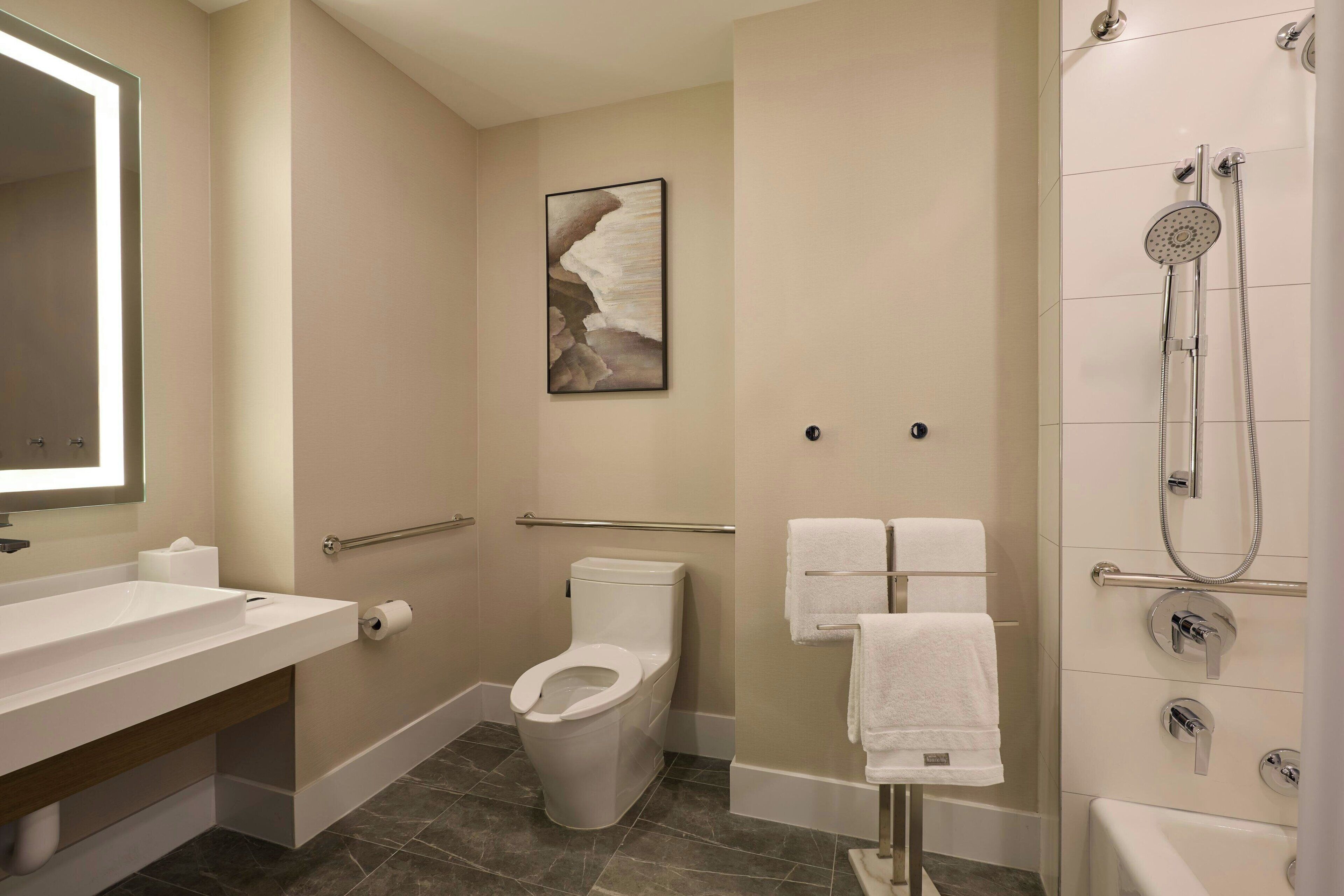 A modern bathroom with a toilet, sink, and shower.