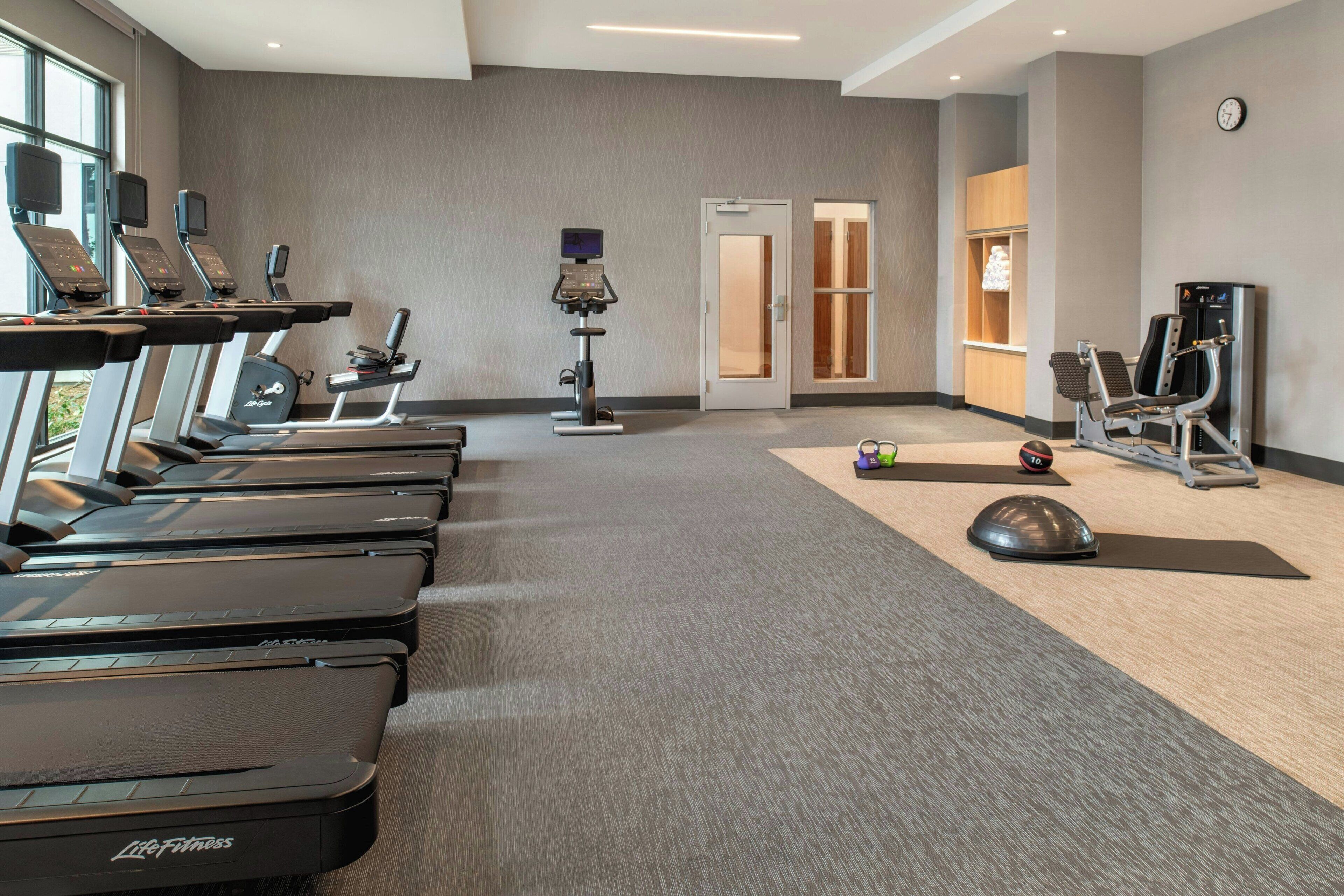 A fitness center with treadmills, a stationary bike, and a rowing machine.