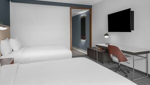 A modern hotel room with a bed, desk, chair, and a flat-screen TV. - Courtyard By Marriott San Bernardino Loma Linda (Loma Linda)