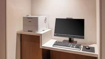 Un bureau moderne équipé d’une imprimante Brother, d’un écran plat, d’un clavier et d’une souris, le tout posé sur un bureau blanc.