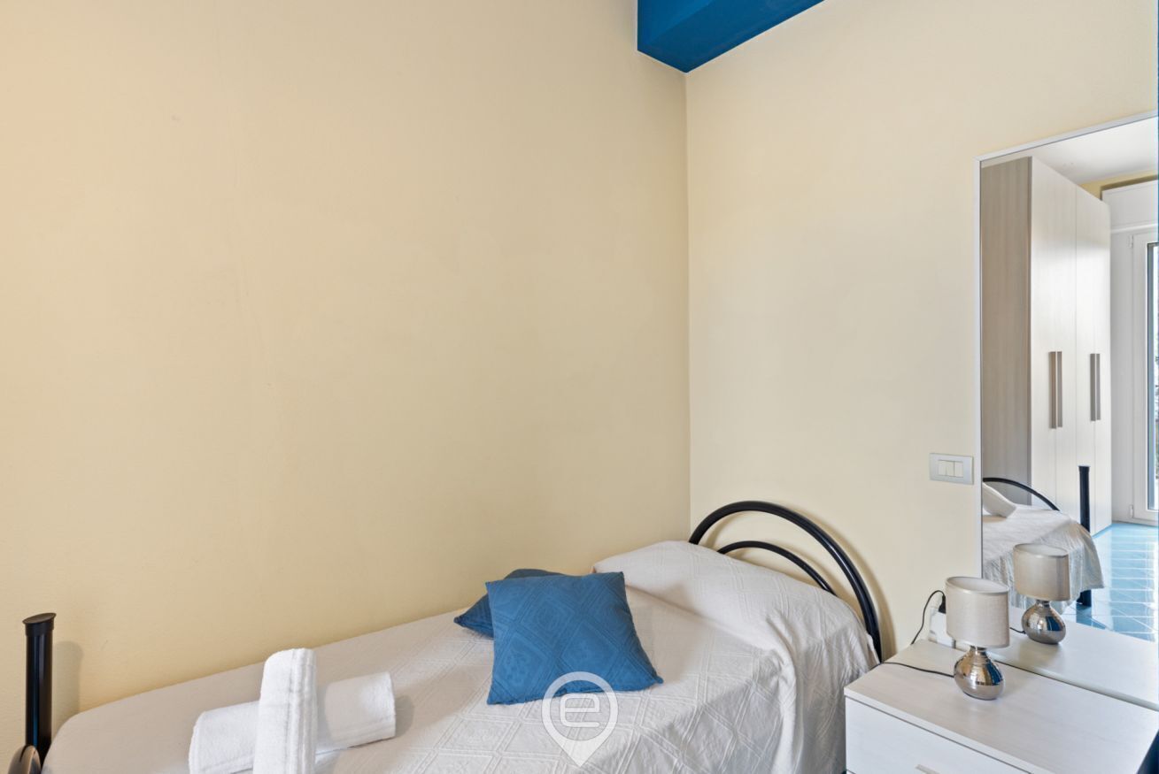 Une chambre d’hôtel avec un lit, une table de chevet avec une lampe et un miroir.