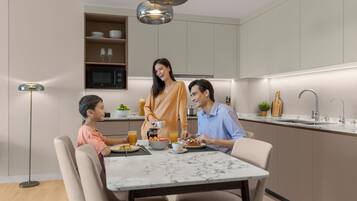 A modern kitchen with a dining table, a microwave, and a sink.