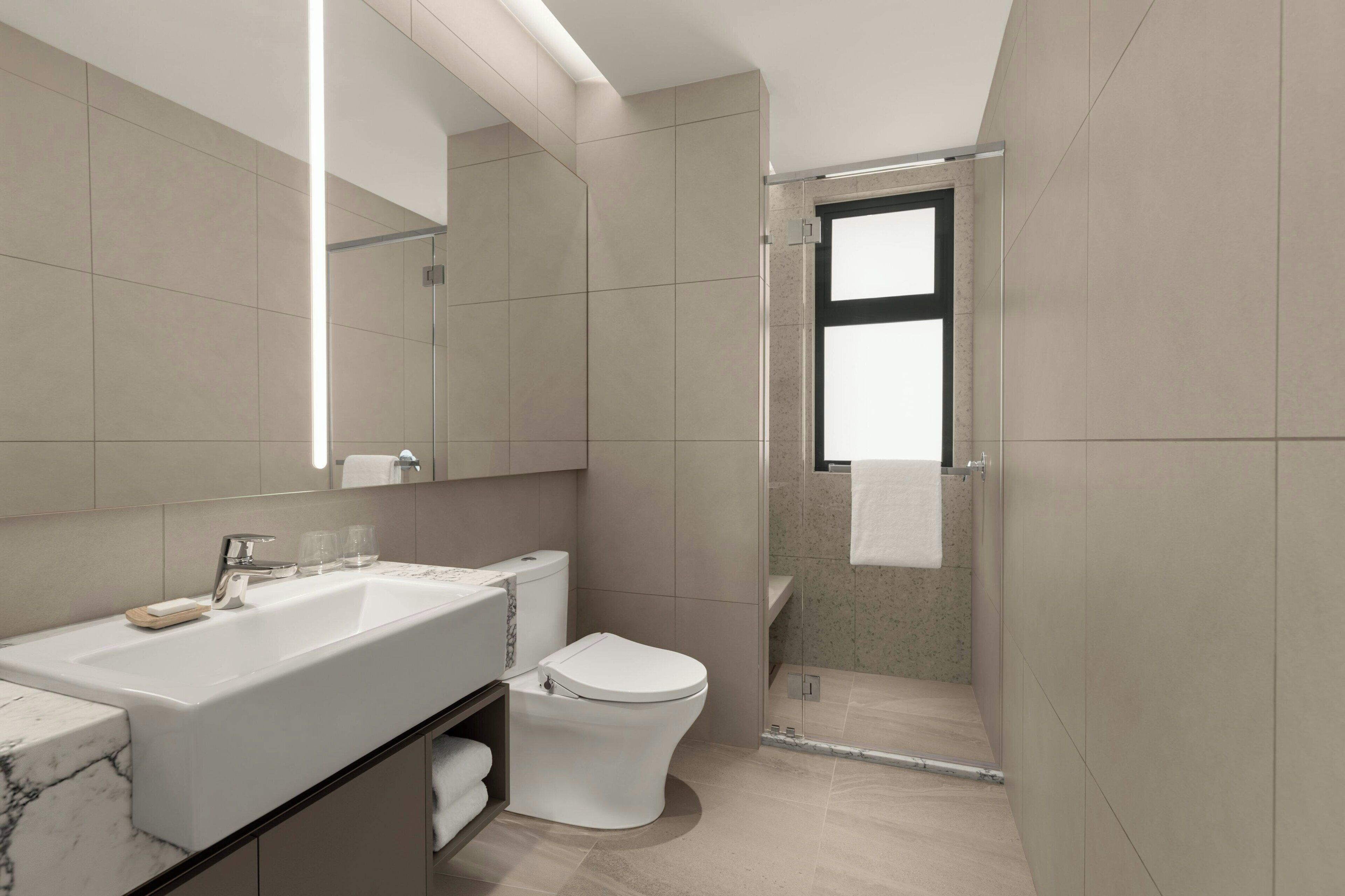 Un baño moderno con un lavamanos grande, inodoro y zona de ducha.