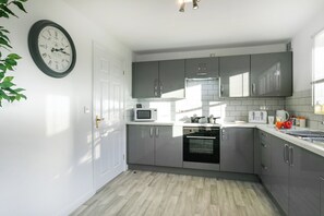 Een microgolfoven, een oven, een kookplaat, een waterkoker