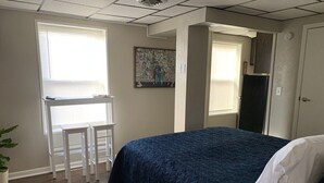 Un dormitorio con cama, escritorio y silla.