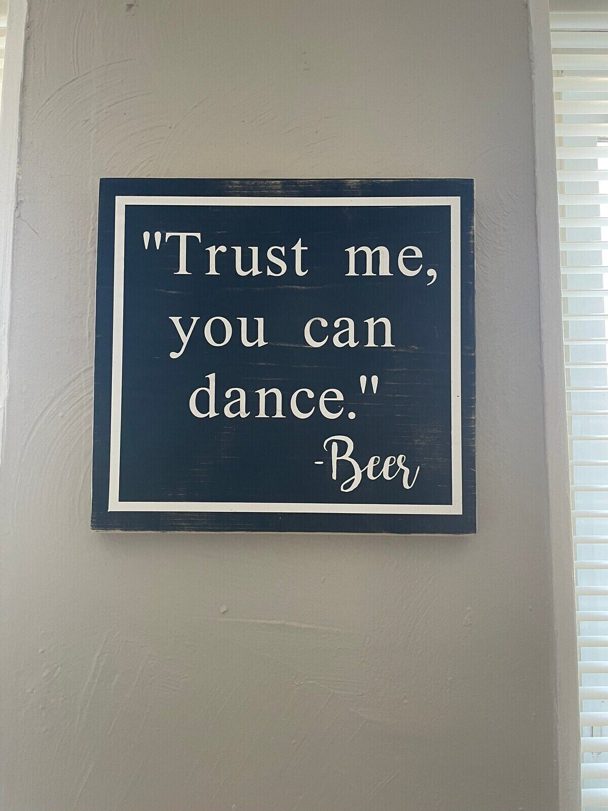 Placa na parede com a frase 'Confie em mim, você consegue dançar.' - Cerveja.