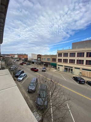A street view with parked cars, buildings, and a clear sky. - 1 Bedroom Apartment in Downtown Coshocton (23) (Coshocton)