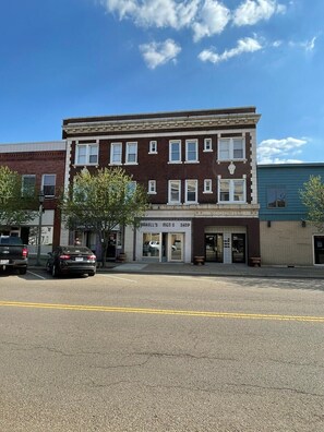 A two-story building with a ground-floor men's shop and a second-floor residential unit. - Studio Apartment on Main Street in Coshocton (35) (Coshocton)