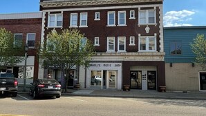 A two-story building with a ground-floor men's shop and a second-floor residential unit. - Studio Apartment on Main Street in Coshocton (26) (Coshocton)