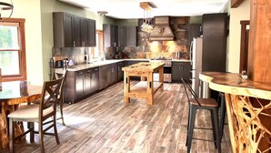 Una cocina moderna con armarios oscuros, una isla central y un respaldo de piedra.