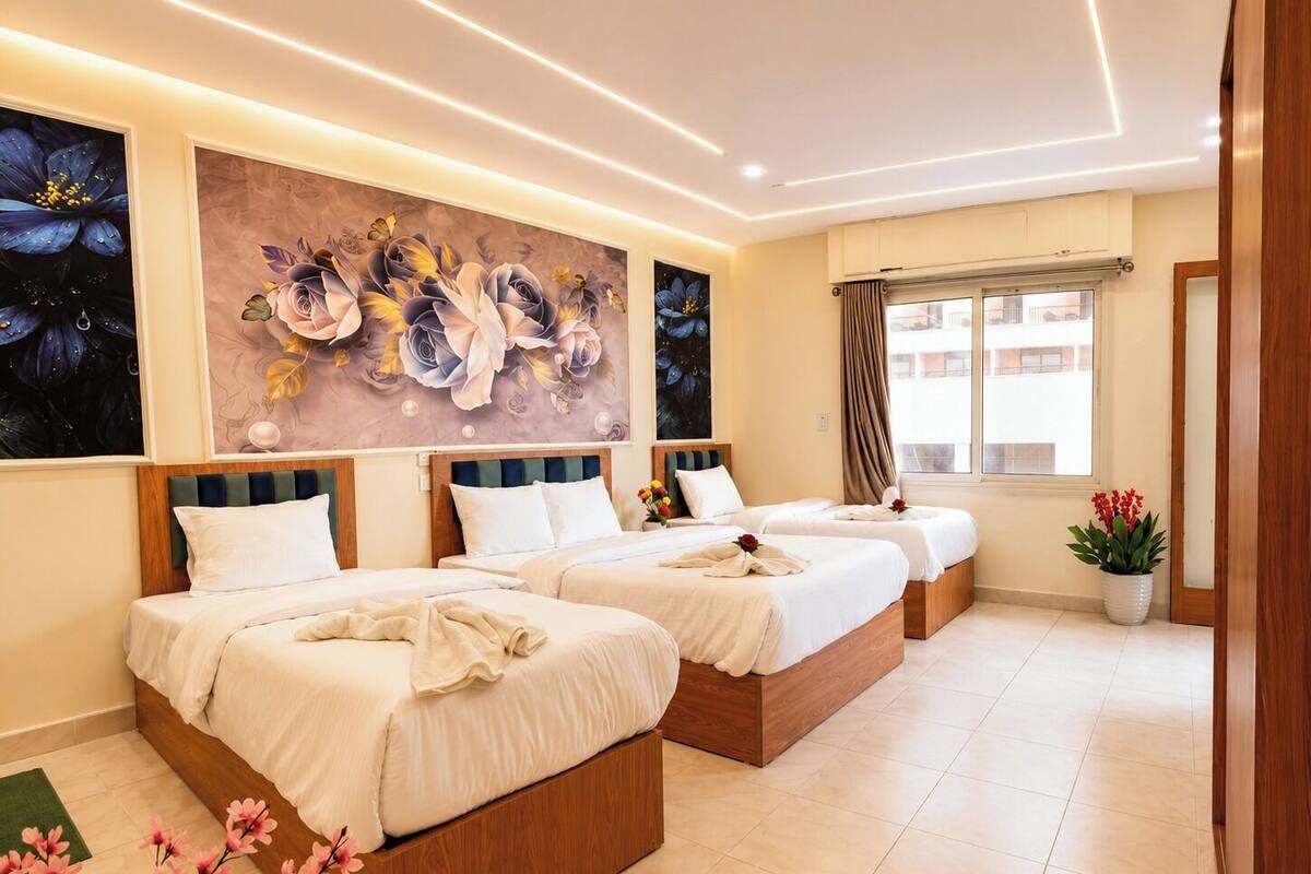 Une chambre d’hôtel avec trois lits, une grande fresque murale à motifs floraux, une fenêtre avec des rideaux et une plante en pot.