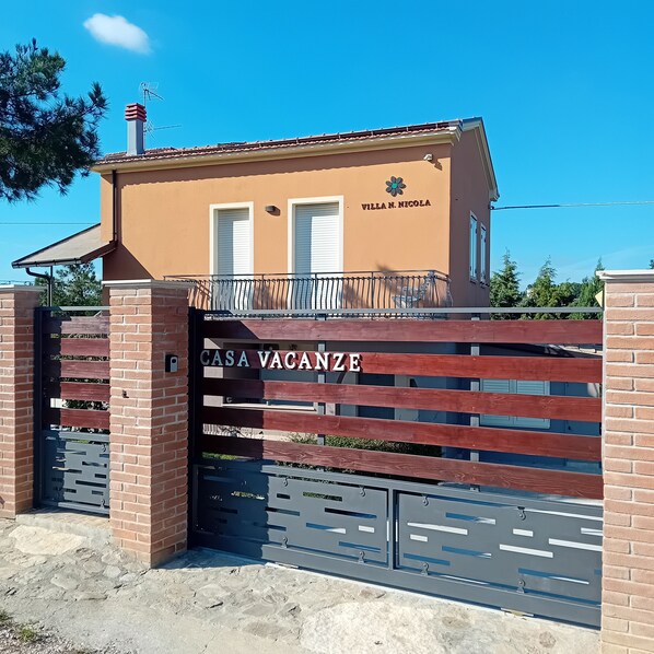 Une villa nommée « Villa N. Nicola », dotée d’une entrée fermée par un portail et portant l’inscription « Casa Vacanze ».