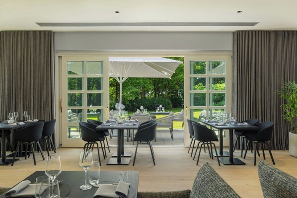 A dining area with tables and chairs, large windows, and a view of the outdoors. - Das Affalterbach, Stuttgart, Autograph Collection (Affalterbach)