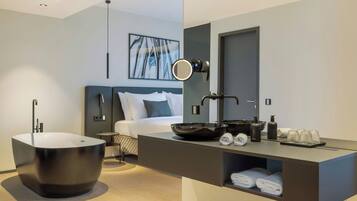 Ein modernes Badezimmer mit einer freistehenden Badewanne, einem Waschtisch mit Spiegel und ordentlich drapierten Handtüchern.