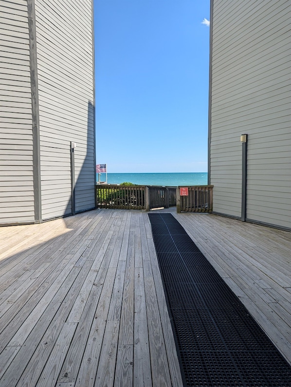 A wooden deck leading to a beach with a clear view of the ocean. - Clean, Oceanfront Condo w/ Pool Access, King Suite, Bunks & Beautiful Views! (North Topsail Beach)