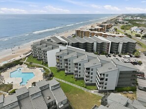 A coastal apartment complex with a swimming pool, beach access, and a view of the ocean. - Clean, Oceanfront Condo w/ Pool Access, King Suite, Bunks & Beautiful Views! (North Topsail Beach)