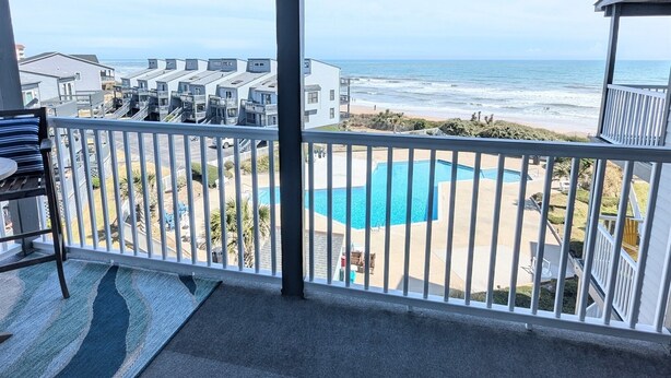 A balcony with a view of the ocean, a pool, and a building complex. - Clean, Oceanfront Condo w/ Pool Access, King Suite, Bunks & Beautiful Views! (North Topsail Beach)