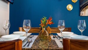 A dining table set with white plates, clear wine glasses, and a vase with decorative flowers. - Poolside in Paradise: Walk to the Beach and More! (Coco)