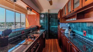 A kitchen with a gas stove, sink, and wooden cabinets. - A place to enjoy. Best views and location in all Montevideo. (Montevideo)