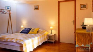 Una camera da letto con un letto, due lampade sui comodini, un tavolino con lampada e una porta.
