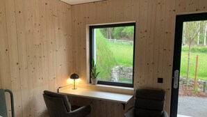 A room with wooden walls, a desk with a lamp, two chairs, and a window with a view of greenery. - Cozy Double Room - Private Entrance – Easy Self Check-In (Rum)