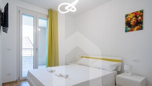 Una habitación de hotel moderna con una cama, una mesita de noche y un cuadro en la pared.