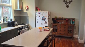 Cucina con isola centrale, mobili in legno, frigorifero e un adesivo decorativo a forma di cervo.