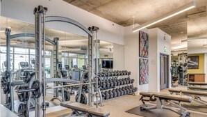 Une salle de sport moderne équipée de divers appareils d’entraînement, notamment des machines de musculation et des haltères.