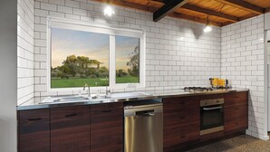 A modern kitchen with a stainless steel dishwasher, double sink, and built-in oven. - Cozy cabin in peaceful Wangoom with AC, WiFi (Wangoom)